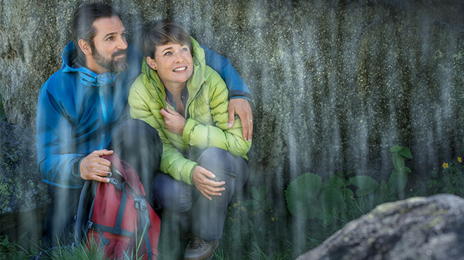 Mann und Frau - unter Felsblock - Schutz vor Regen 